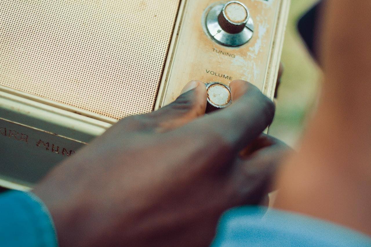 hand on the knob of an old fashion radio