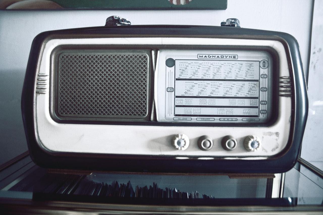 an old-fashioned radio on a glass table ride the airwaves