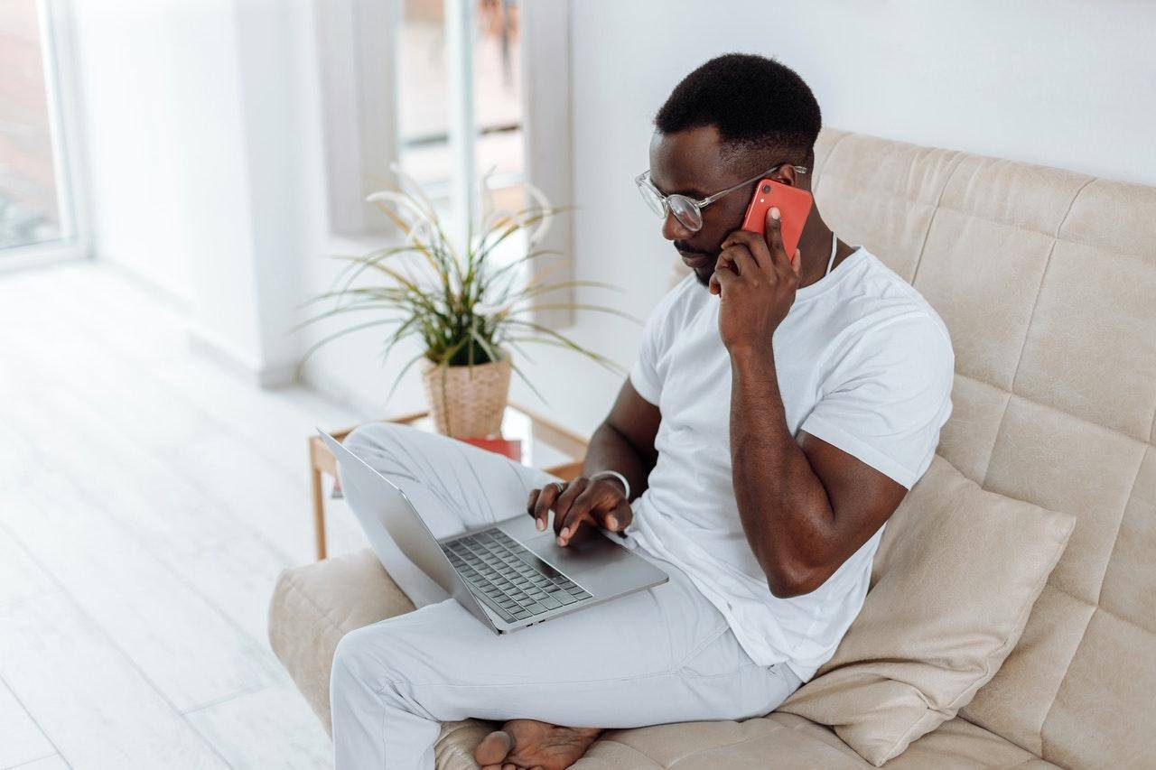 man on sofa using cell phone