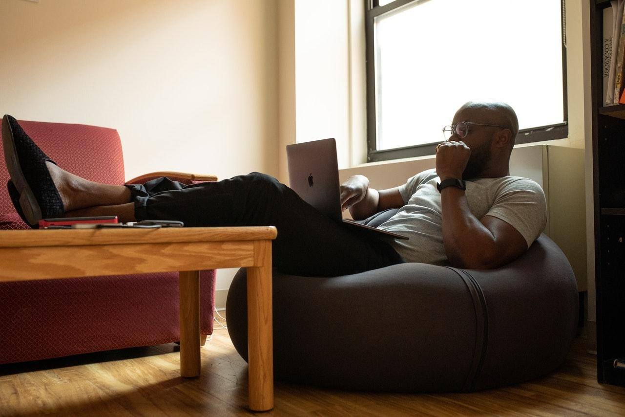 man sitting on ergonomic cushion with laptop the new workplace at home