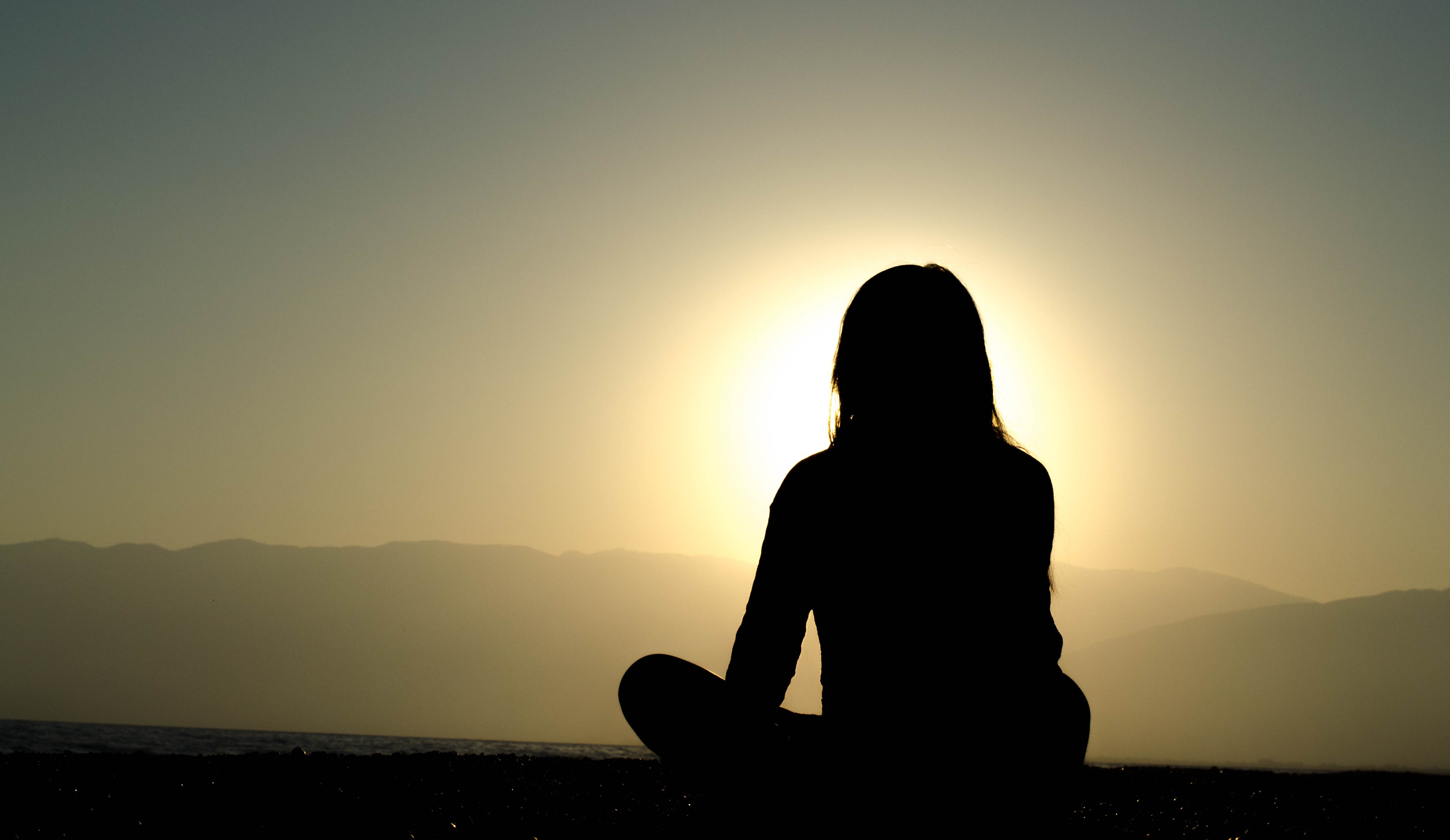 daily practice of meditation shadow of a woman sitting in lotus position