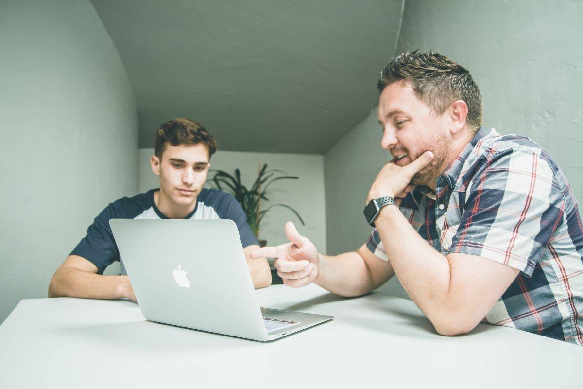 mentor and student looking at open computer