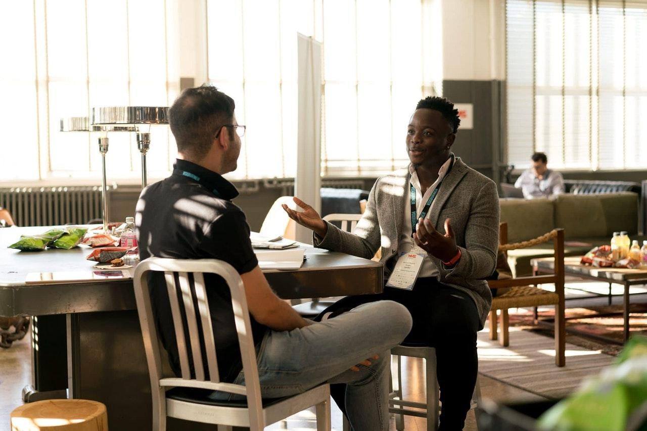 mentor and young man talking in an office